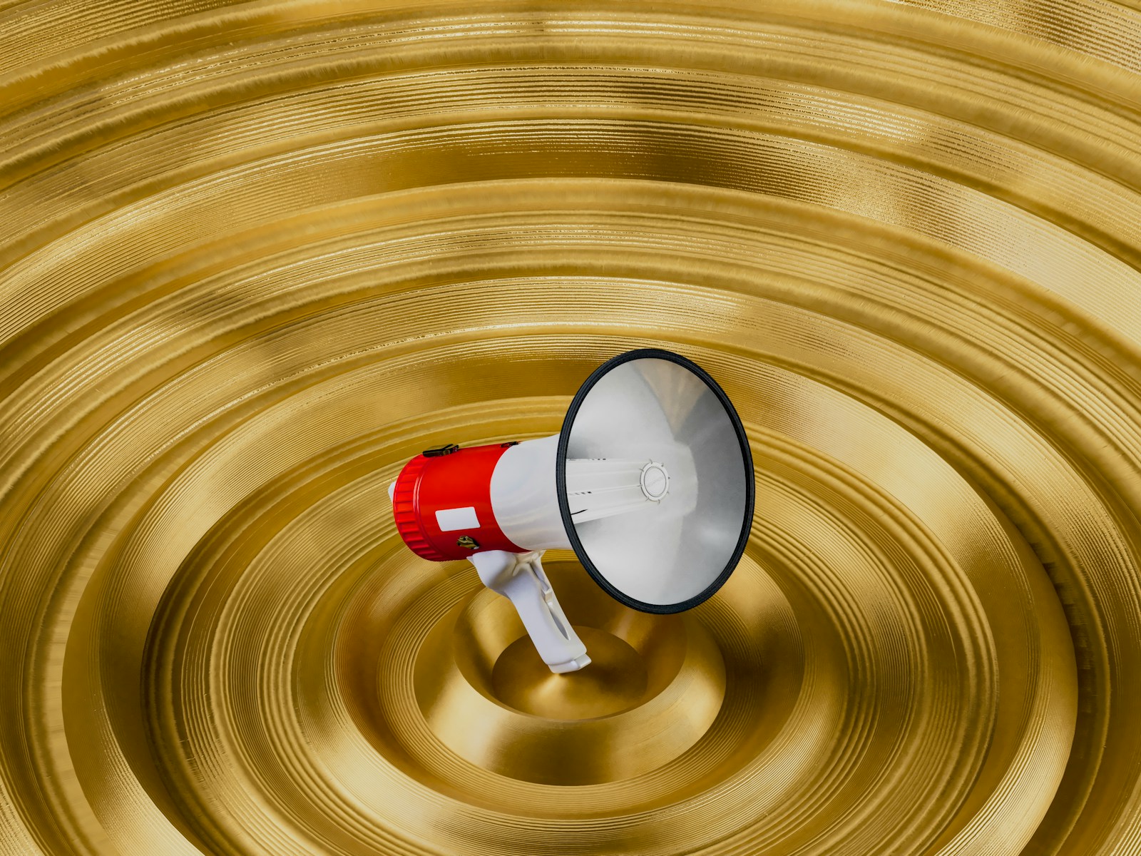 A red and white bullhorn is in a golden bowl