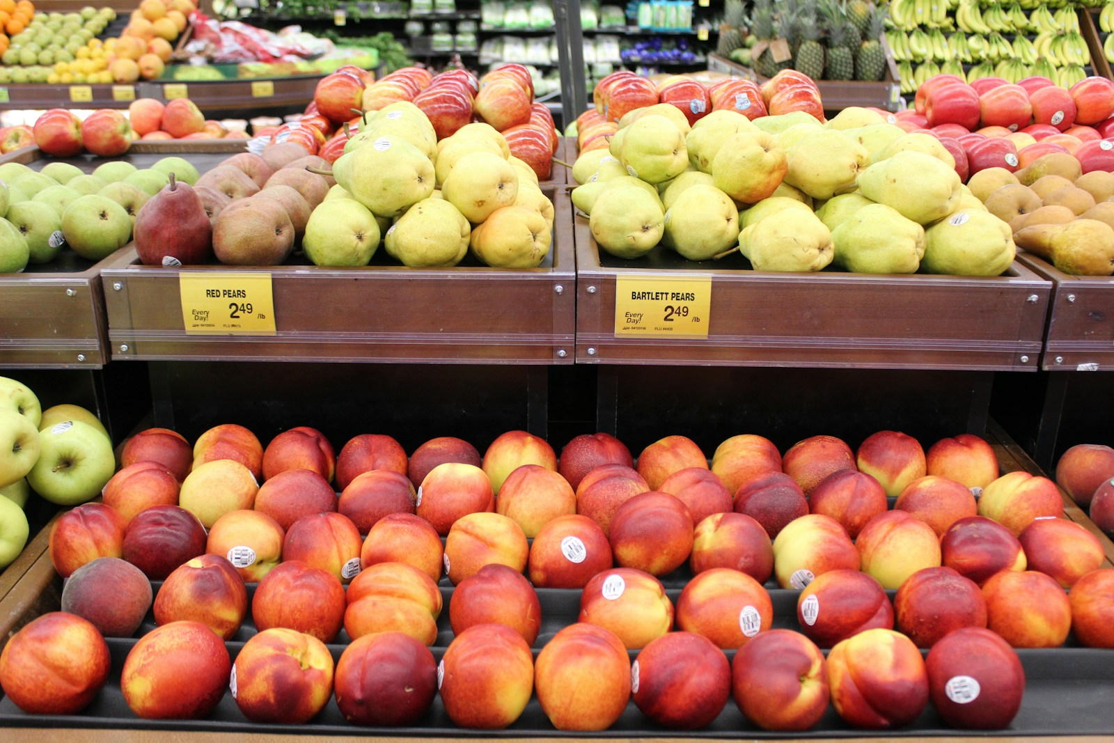 apples and pears are on display in a grocery store