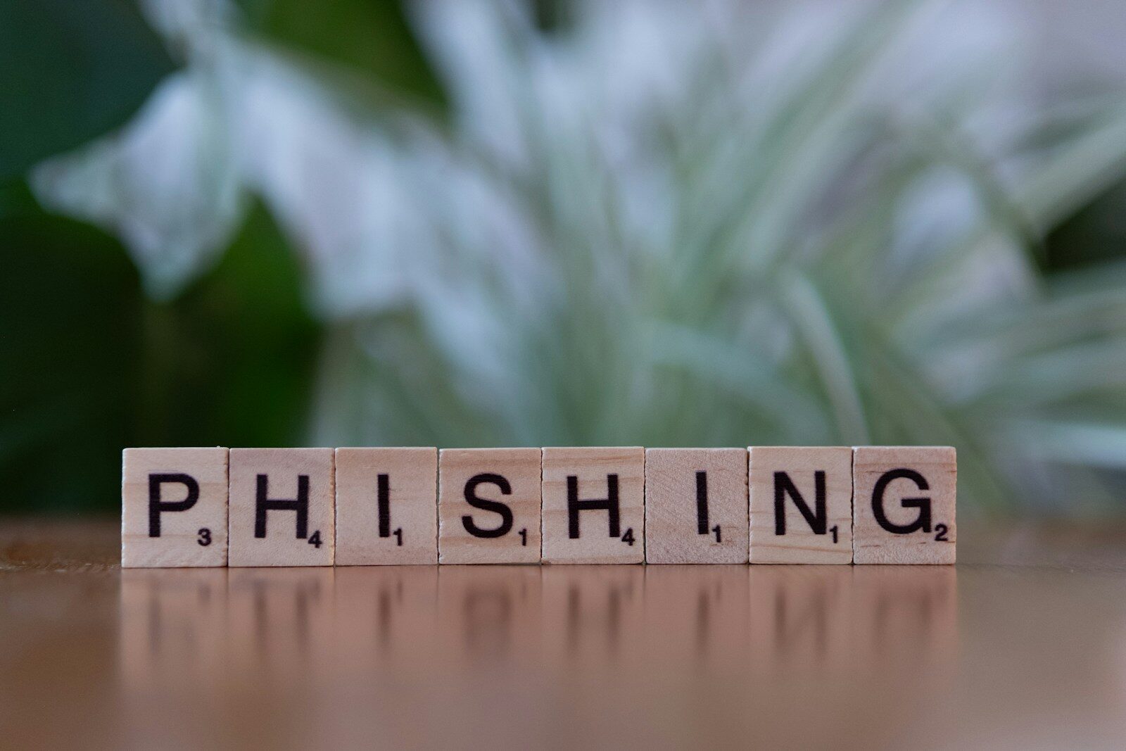A wooden block spelling phishing on a table